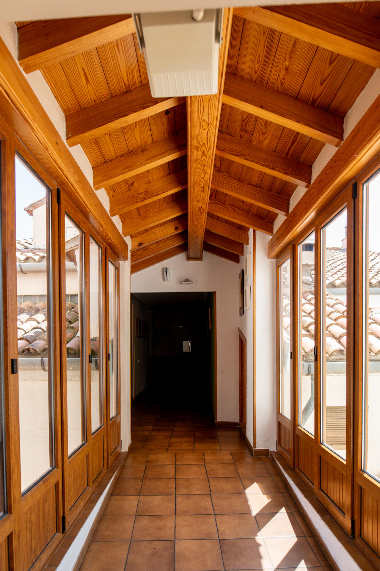 Pasillo luminoso con vigas de madera del hotel